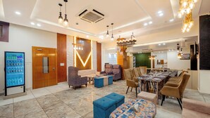 Un'ampia hall dalle linee moderne, con un'area salotto, un tavolo da pranzo e un distributore automatico di bevande.