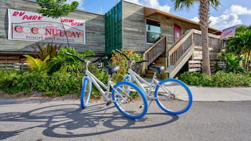 A bicycle parked in front of a building with a sign indicating 'RV Park Now Open' and 'Coconut Cay Resort and Marina'.