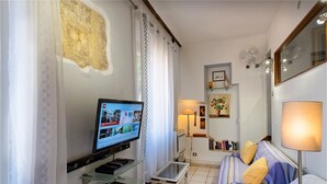 A living room with a television, a sofa, a coffee table, and a lamp. - Adorable 2-bedroom apartment with AC in old town Antibes (Antibes)
