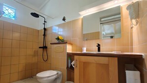Casa de banho moderna com sanita, chuveiro e lavatório.