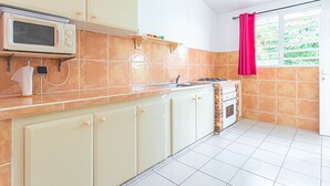 Una cucina dotata di microonde, fornelli e pensili.