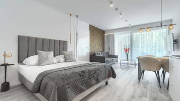 Een moderne slaapkamer met een groot bed, nachtkastjes, een bureau en een stoel.
