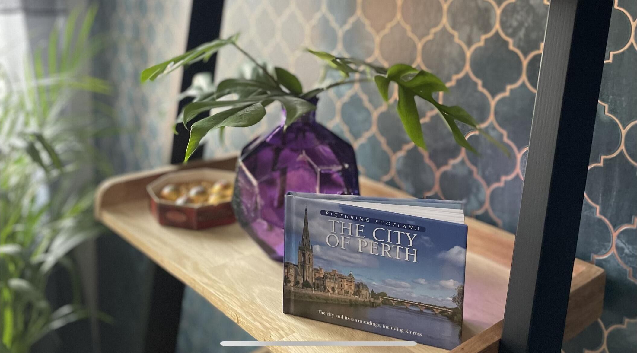 Un livre intitulé « La ville de Perth » est posé sur une étagère en bois.