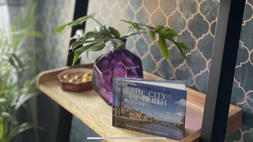 Un livre intitulé « La ville de Perth » est posé sur une étagère en bois.