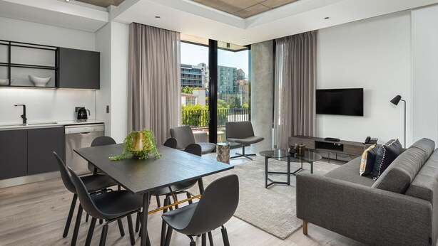 A modern apartment with a dining area, living room, and balcony with city views. - The Signature G07 (Cape Town)