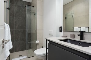 Apartamento empresarial | Banheiro | Chuveiro, secador de cabelo, toalhas de banho 