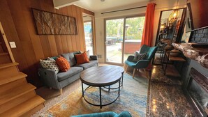 A modern living room with a sofa, coffee table, and a fireplace. - Lakeside Living with HotTub, Kayaks, Paddleboard; close to Olympic National Park (Port Angeles)