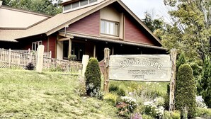 Un bâtiment sur lequel est apposée une enseigne indiquant « Bureau du complexe sportif Sugar House », entouré d’un jardin bien entretenu et d’une clôture en bois.