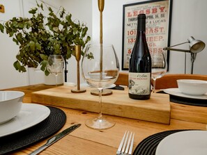A dining table with a bottle of wine, glasses, and cutlery. - Perfect for exploring the Wolds and Lincoln - Pass the Keys (Market Rasen)