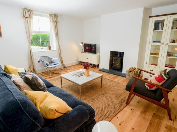 A living room with a sofa, armchair, coffee table, fireplace, TV, and bookshelves. - Perfect for exploring the Wolds and Lincoln - Pass the Keys (Market Rasen)