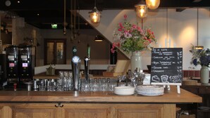 A bar area with a wooden counter, glasses, and a chalkboard menu. - Boutique Hotel Weesp (Weesp)