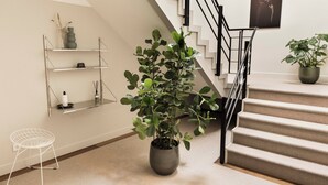 A staircase with a modern design, a potted plant, and minimalist shelving units. - Boutique Hotel Weesp (Weesp)