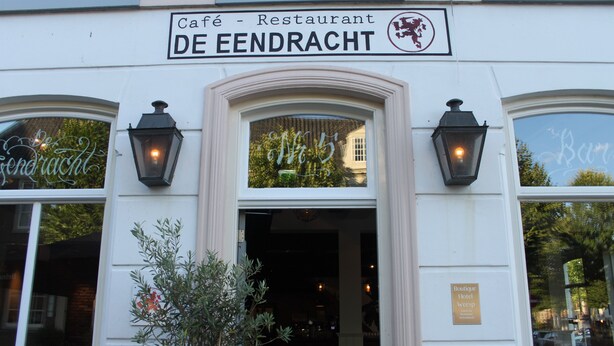A building with a sign reading "Café - Restaurant DE EENDRACHT" and a "Boutique Hotel Weesp" sign. - Boutique Hotel Weesp (Weesp)