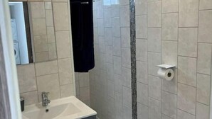 Une salle de bain moderne équipée d’une douche, d’un lavabo et de toilettes.