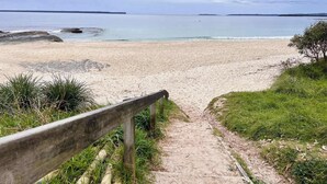 A sandy beach with a wooden pathway leading to the water. - Husky Sol Coastal escape, walk to beach and cafes (Huskisson)