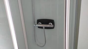 Chuveiro, secador de cabelo, toalhas de banho, papel higiênico