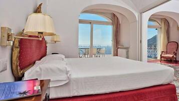 Una camera d'albergo con un letto, una lampada, una sedia e vista sull'esterno.