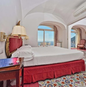 A hotel room with a bed, a lamp, a chair, and a view of the outside.