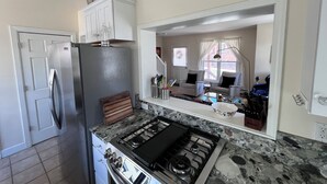 Una cocina con estufa, refrigerador y armarios.