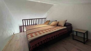 Une chambre à coucher avec un lit, une table de chevet et une petite table.