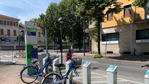 A bicycle parked at a public bike-sharing station with a city street and buildings in the background. - Charming apartment in Parma (Parma)
