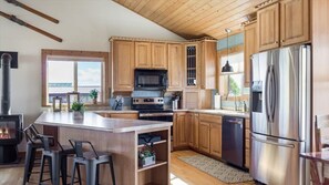 Enjoy cooking in this kitchen with a central island, bar stools, and a stainless steel refrigerator.