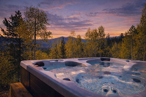 A hot tub with a view of mountains and trees.