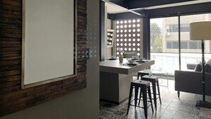 A modern kitchen with a large island, bar stools, and a view of the city through large windows. - Increible depto en la Condesa cama King Size (Ciudad de México)