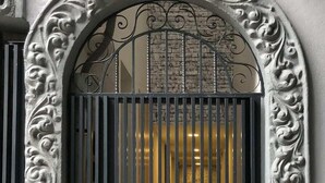 An ornate metal gate with vertical bars, set within an arched stone frame with intricate carvings. - Increible depto en la Condesa cama King Size (Ciudad de México)