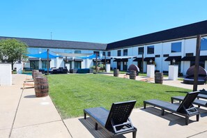 A courtyard with outdoor seating, a pool, and a building with multiple windows.
