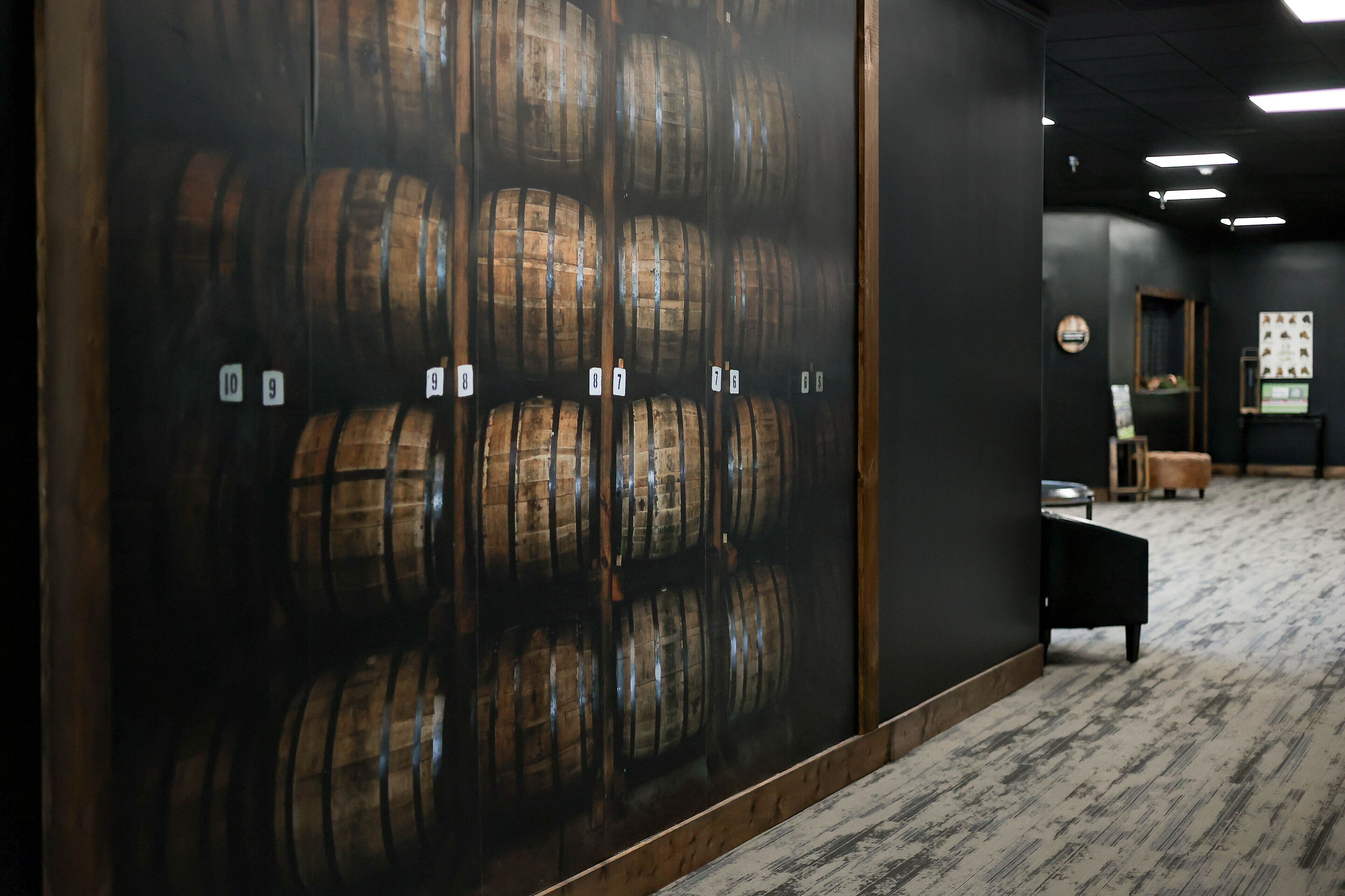 A room with wooden barrels lined up against the wall, numbered from 7 to 10.