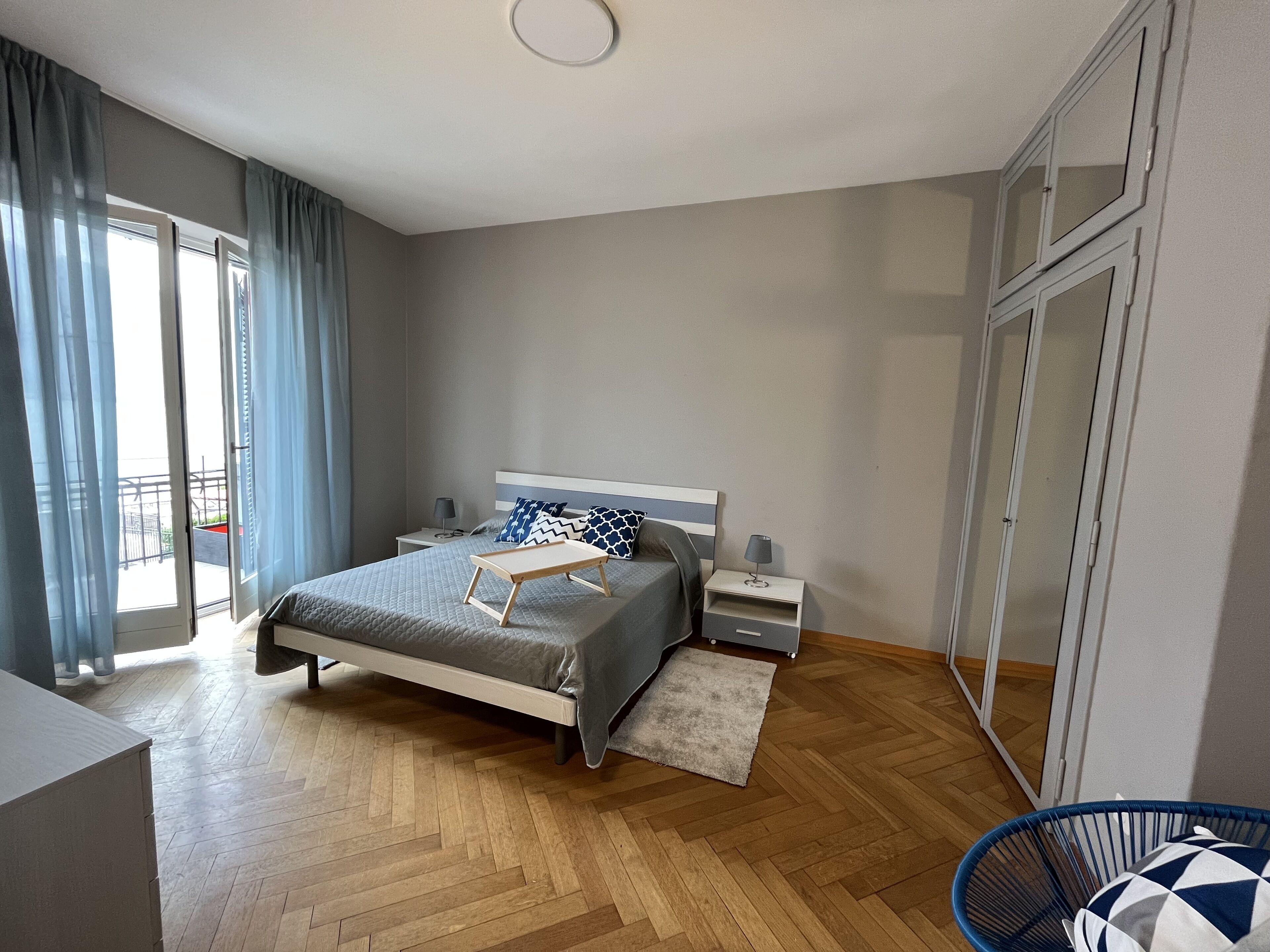Una camera da letto con un letto, comodini, una sedia e vista sull'esterno.