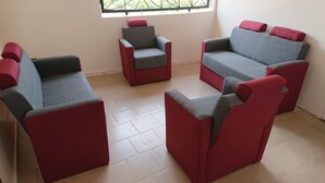 A seating area with four armchairs and a sofa, arranged in a semi-circle. - LA CASE A MAMY (Nianing)