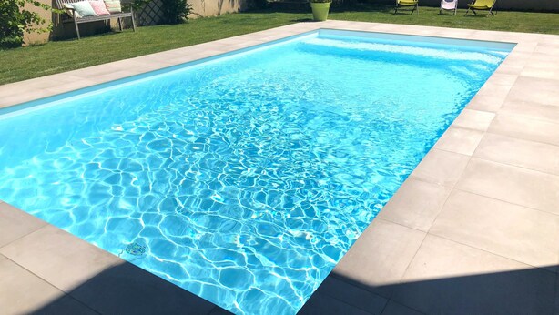 A rectangular swimming pool with clear blue water and a tiled edge. - LA CASE A MAMY (Nianing)