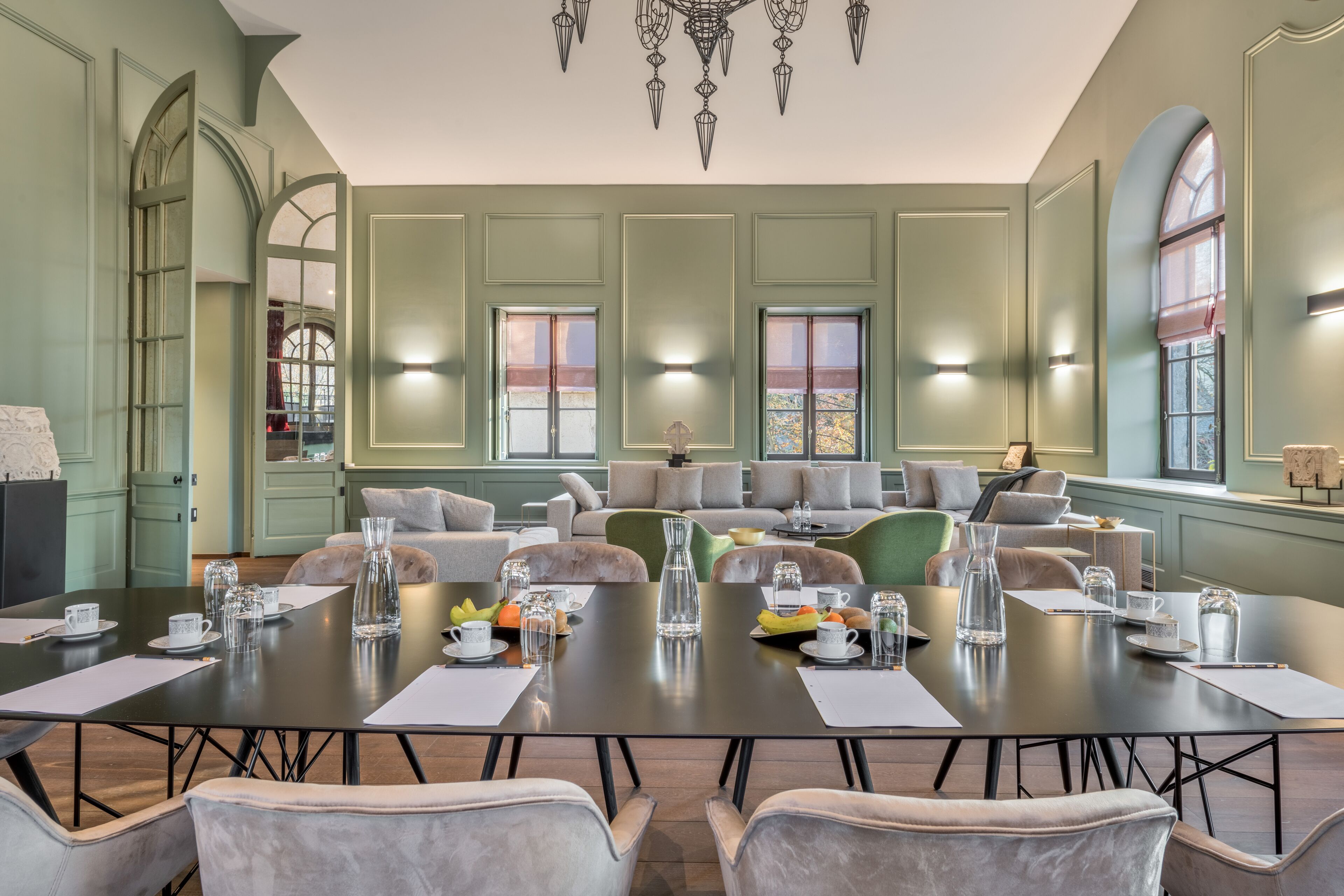Une salle de conférence spacieuse, dotée d’une longue table, de nombreuses chaises et d’un coin salon avec des canapés.