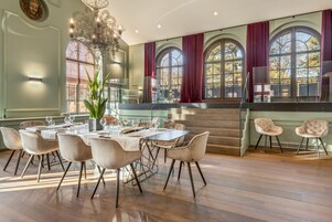 Uma sala de jantar com uma mesa comprida, cadeiras e um candelabro.