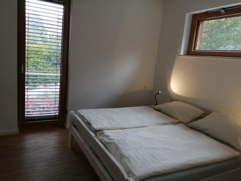 Quarto com cama, janela e porta.