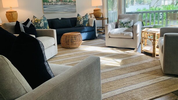 A living room with a sofa, armchairs, a coffee table, and a painting on the wall. - Sleeps 9! Serene Sea Palms Golf Condo on St Simons|Close to Beach, Restaurants!  (St. Simons Island)