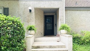 A concrete staircase leading to a dark door with the number 652. There are two potted plants on either side of the steps. - Sleeps 9! Serene Sea Palms Golf Condo on St Simons|Close to Beach, Restaurants!  (St. Simons Island)