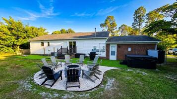 A house with a patio area featuring outdoor furniture and a grill.