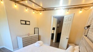 Una camera da letto con un letto, una testiera in legno, un comò e uno specchio.
