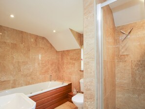 A modern bathroom with a freestanding bathtub, a toilet, and a shower enclosure. - Ellenhall Farm Cottage (Stafford)