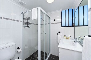 Studio | Badkamer | Een douche, een haardroger, handdoeken, zeep