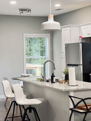 Enjoy cooking in this well-equipped kitchen with a sleek island, stainless steel sink, and high-arc faucet.