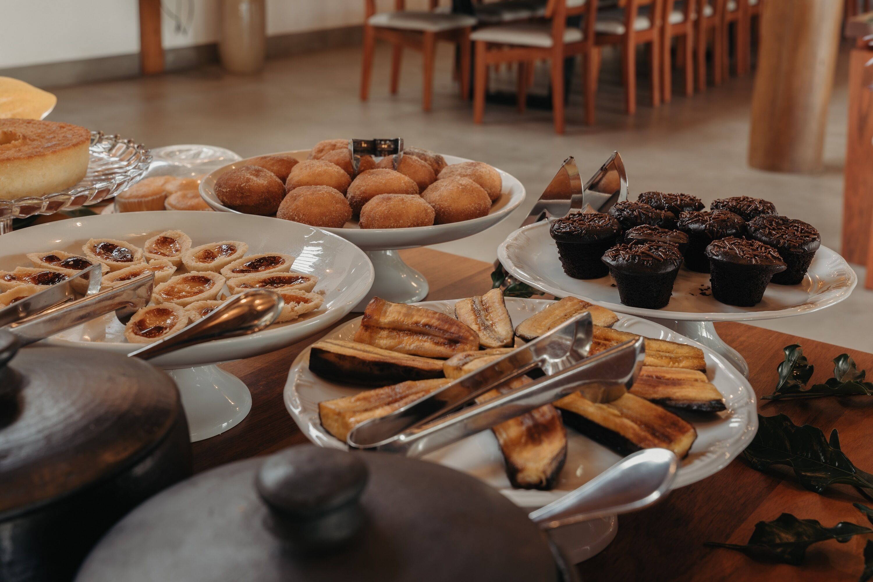 Une table de buffet proposant une variété d’aliments, notamment des pâtisseries, du pain et des confiseries au chocolat.