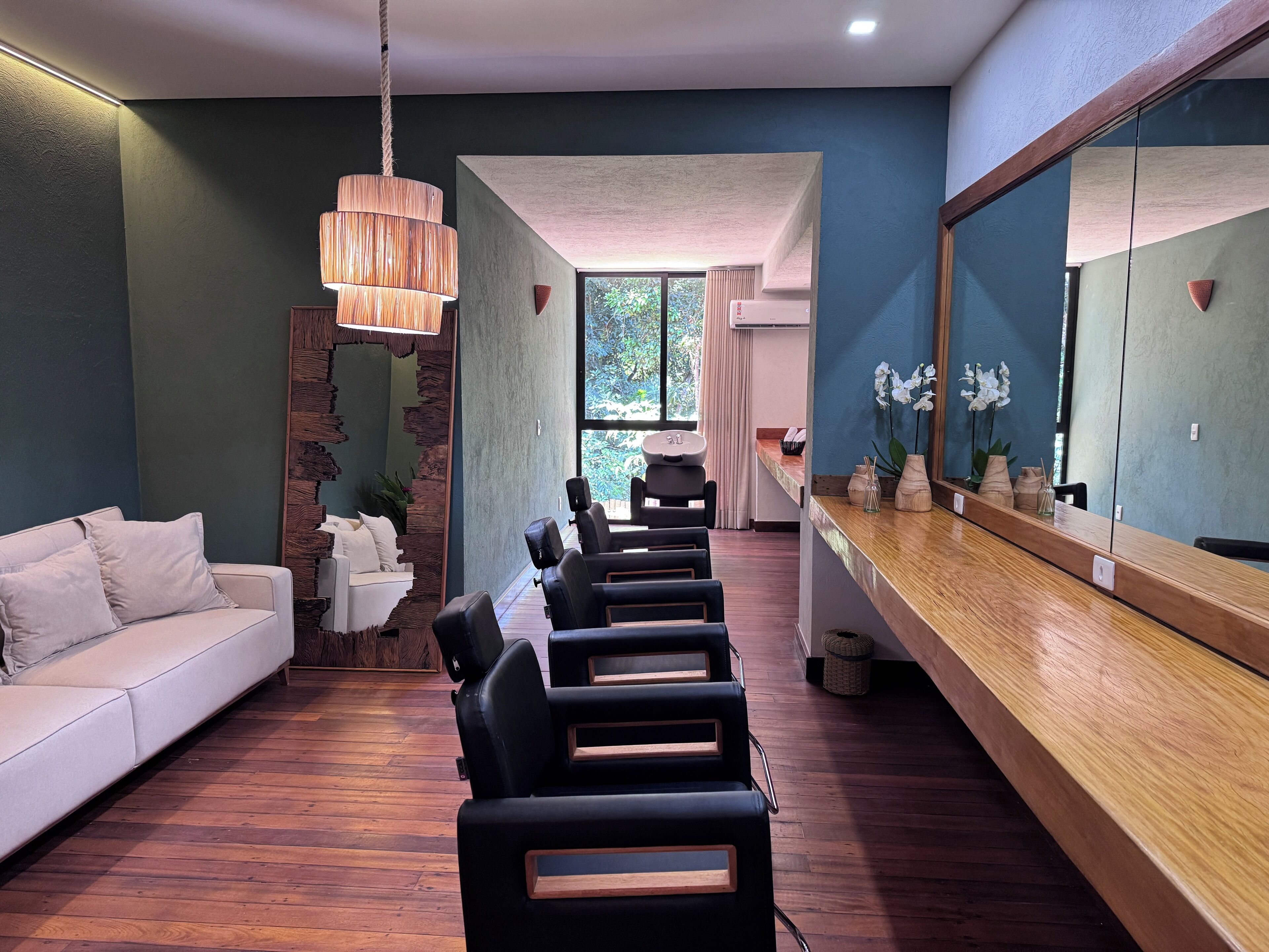A modern interior with a wooden reception desk, a white sofa, and black chairs.