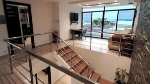 Un interior moderno con una escalera, una zona de comedor y un sofá.