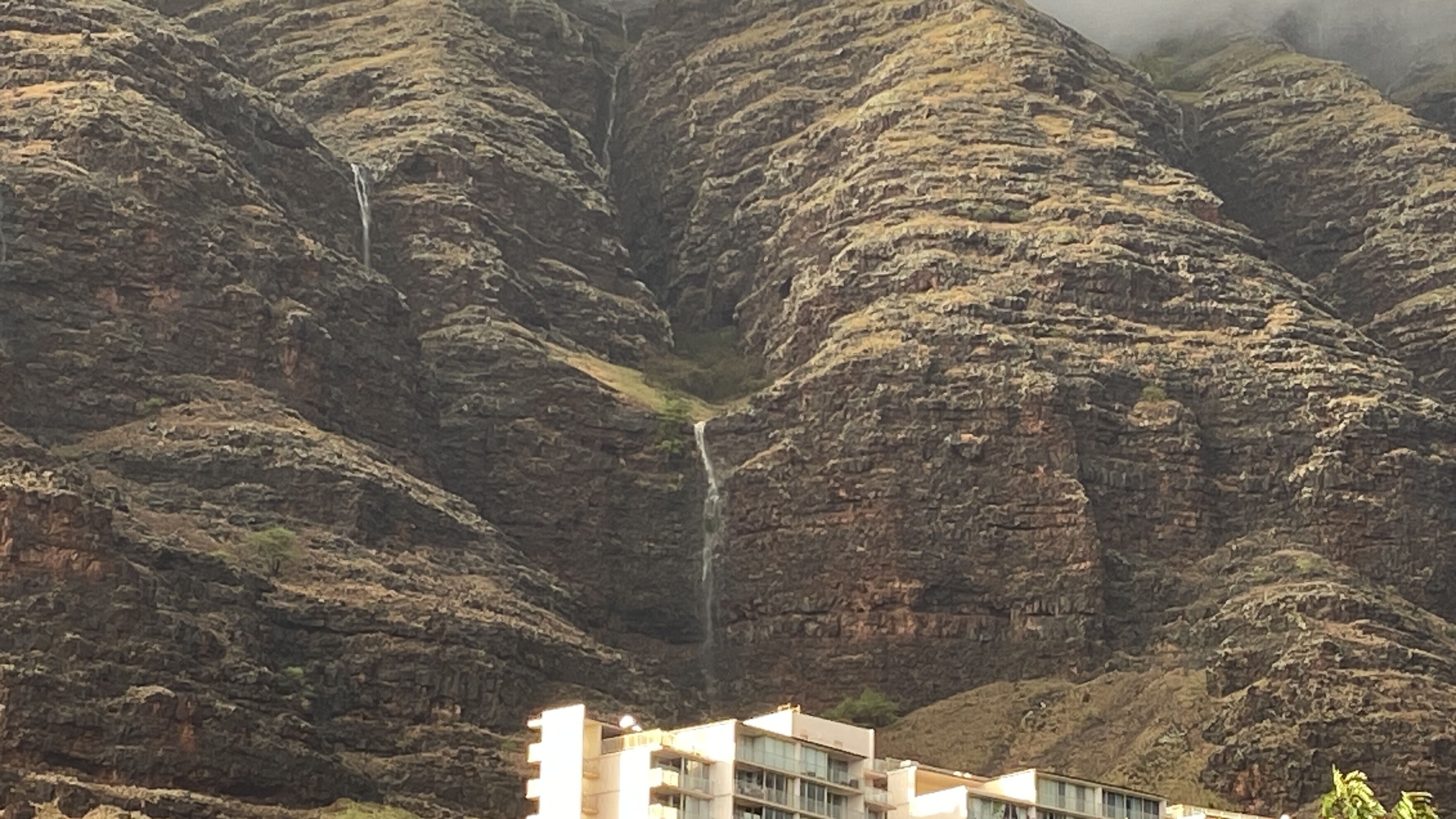 Ein Gebäude mit einem Wasserfall im Hintergrund.
