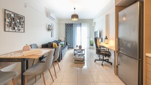 A modern kitchen with a refrigerator, dining table, chairs, and a coffee table.