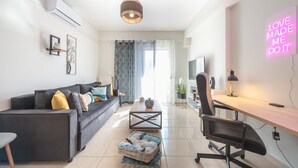 A modern living room with a sofa, coffee table, and a desk with a chair.